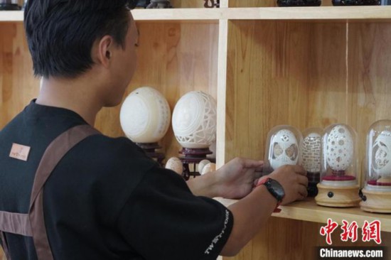 圖為學(xué)生展示創(chuàng)作的蛋雕作品?！《∷迹俊z